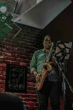 Performer on stage playing saxophone.
